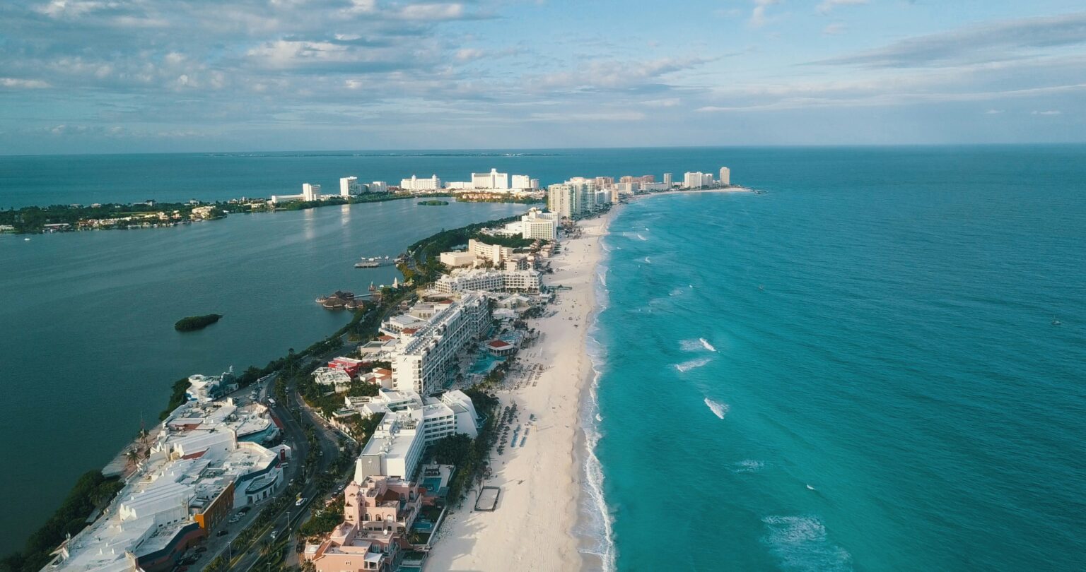 Aerial view of Cancun beach with turquoise ocean white sand and resort buildings along the coast