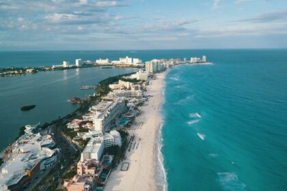 Aerial view of Cancun beach with turquoise ocean white sand and resort buildings along the coast