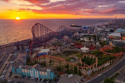 Aerial view of Blackpool Pleasure Beach with roller coasters, the seaside, and a sunset sky best theme parks in England