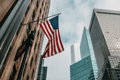 American flag hanging between tall city buildings in a USA downtown area