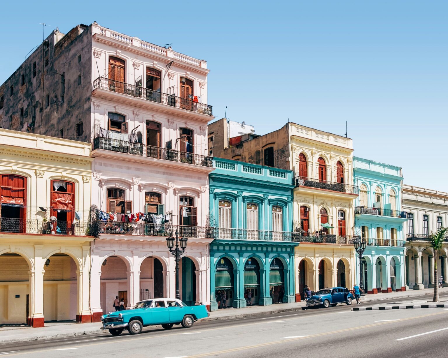 Colorful colonial buildings and classic vintage cars on the streets of Havana Cuba — a top destination for Americans who want to travel to Cuba