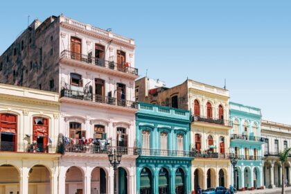 Colorful colonial buildings and classic vintage cars on the streets of Havana Cuba — a top destination for Americans who want to travel to Cuba