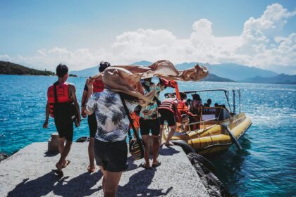 Travelers boarding a boat for overseas adventure travel on a tropical blue sea