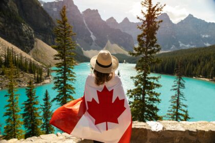 Hiking Trails in Canada with a traveler overlooking a turquoise mountain lake.