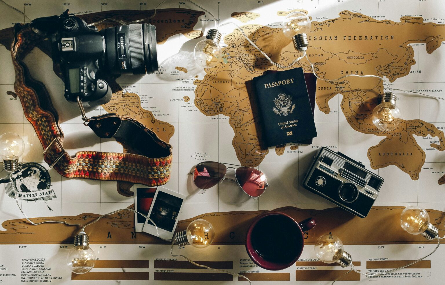 Best travel camera flat lay with passport, sunglasses, and world map