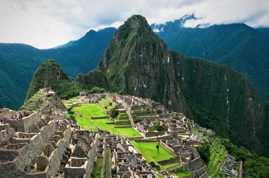 The Machu Picchu ruins with green terraces and Huayna Picchu peak behind, the classic machu picchu travel view