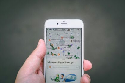 A hand holding a phone with a map and ride app open, showing one of the best travel apps in use
