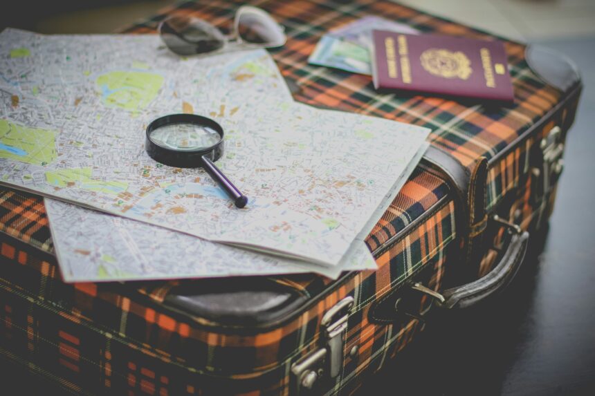 Best places to travel in February shown by a packed suitcase with maps, sunglasses, and a passport
