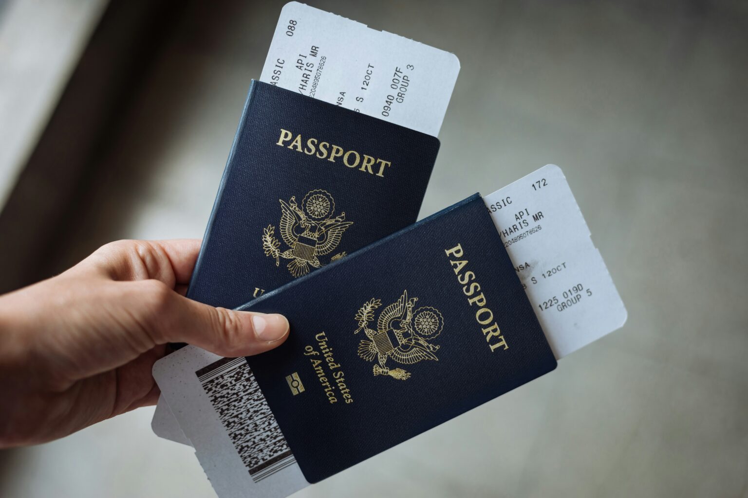 Travel reimbursement for work trips shown by a hand holding two US passports with boarding passes