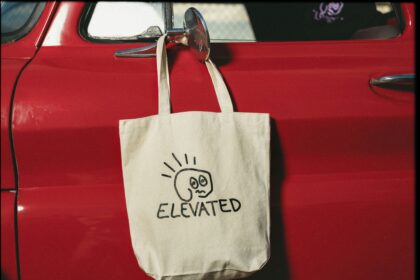 Canvas travel tote hanging on a vintage red car door mirror