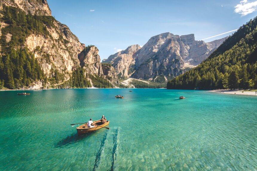 Wooden rowboats on turquoise Lago di Braies, one of the best places to travel in September in the Italian Dolomites