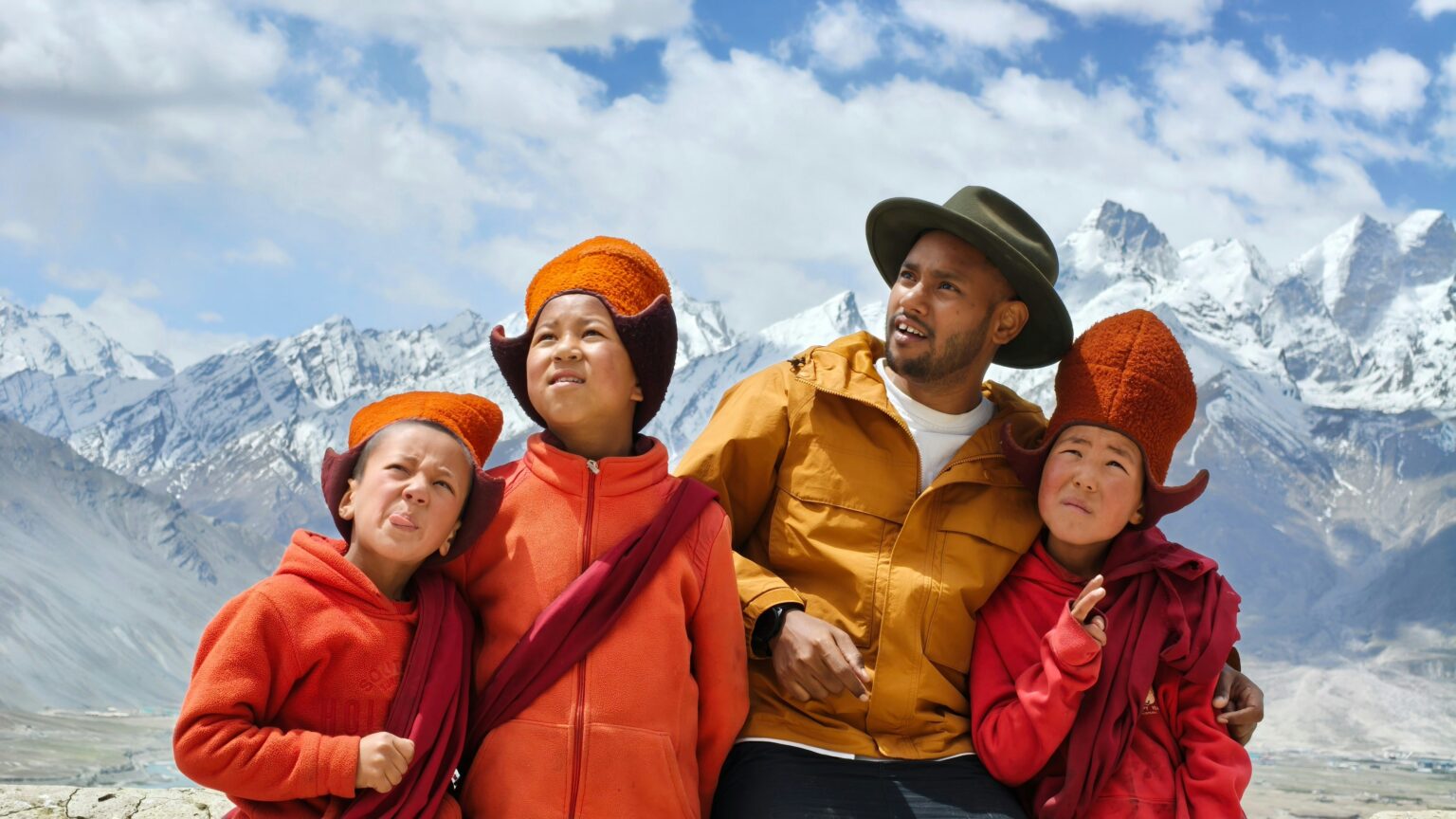 Family and children smiling in mountain travel gear representing best family travel insurance for trips abroad