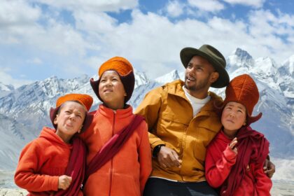 Family and children smiling in mountain travel gear representing best family travel insurance for trips abroad
