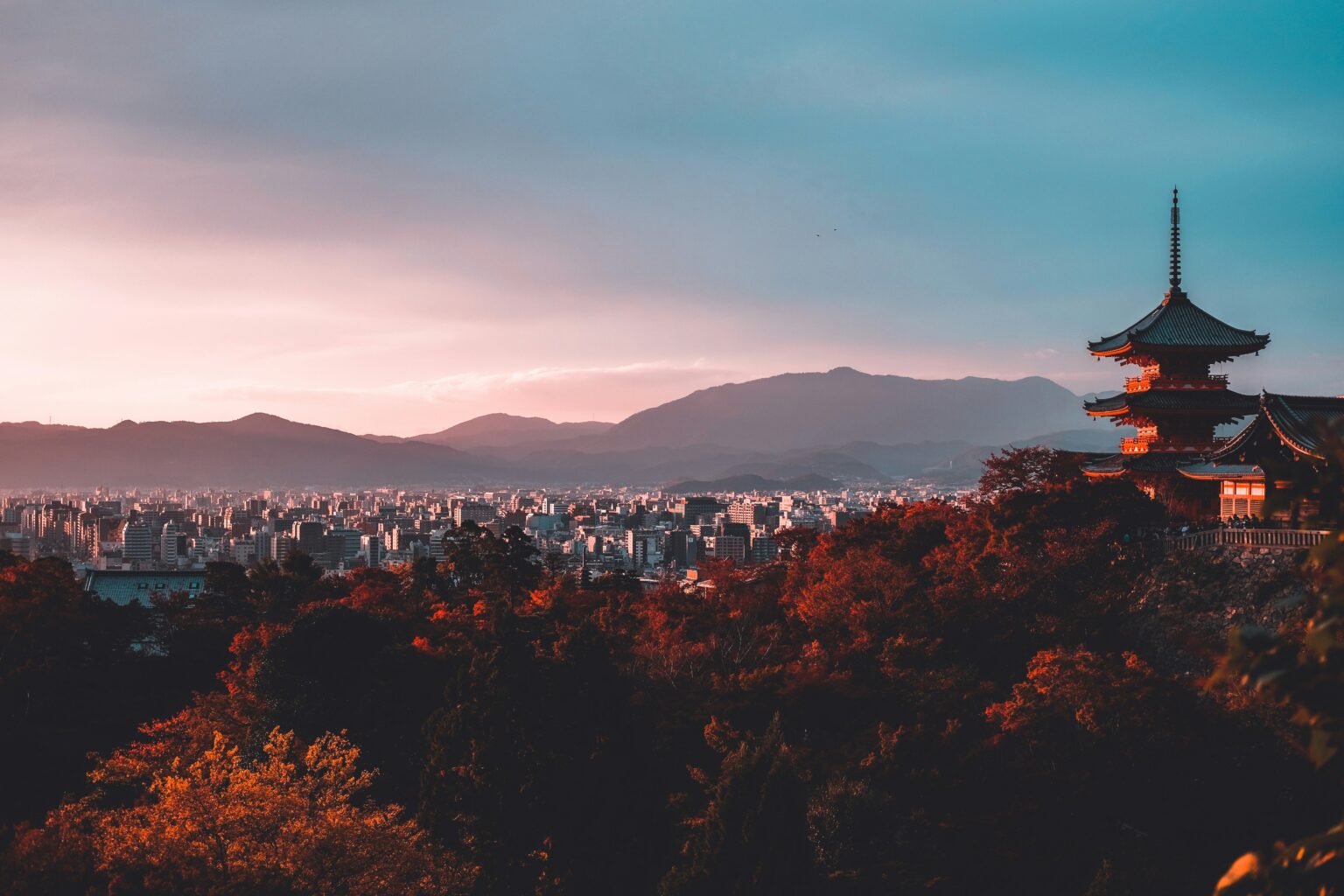 Kyoto pagoda and city skyline with autumn leaves showing the best time to travel to Japan