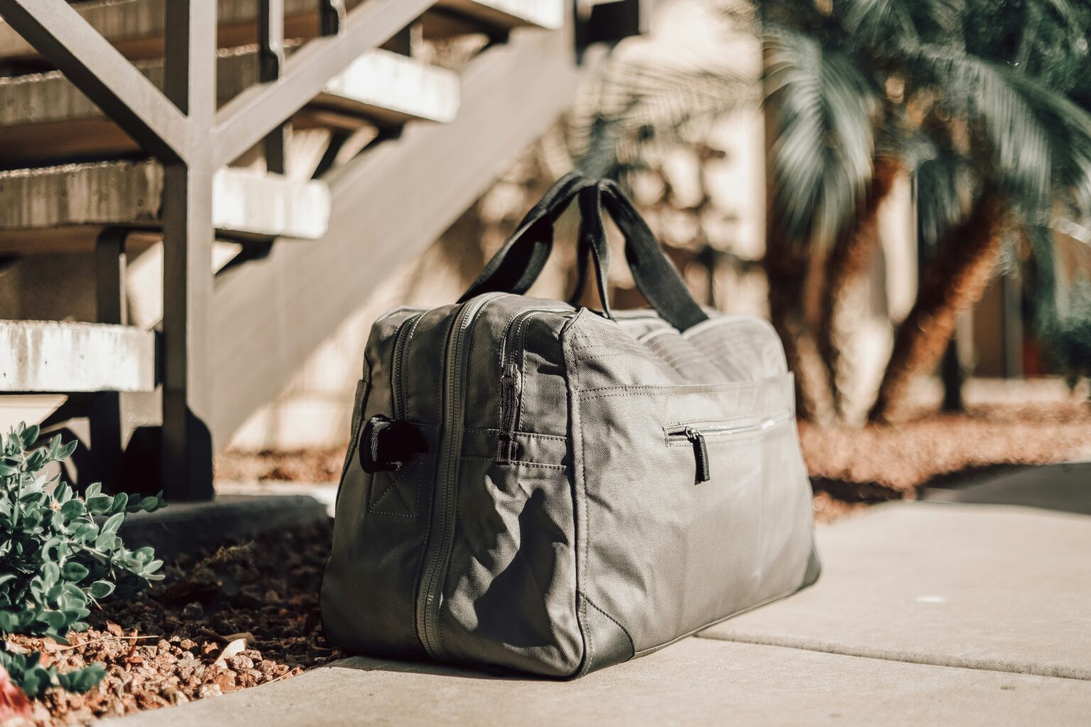 A gray weekender style tote bag with a zip top, one of the roomier travel tote bags for short trips
