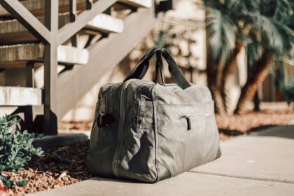 A gray weekender style tote bag with a zip top, one of the roomier travel tote bags for short trips