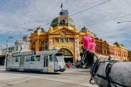 A yarra trams tram and horse carriage outside Flinders Street Station when you travel to Melbourne