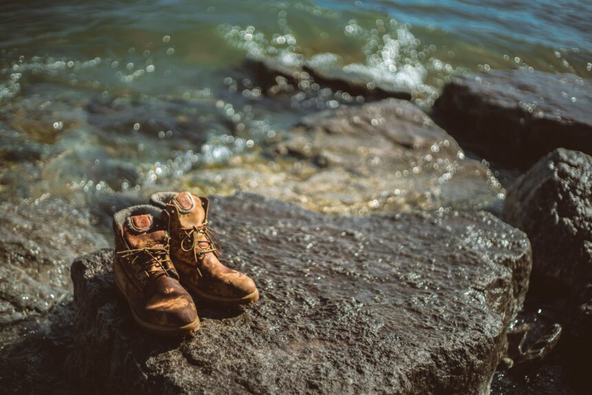 How to clean hiking boots shown by muddy boots being scrubbed with a brush and water