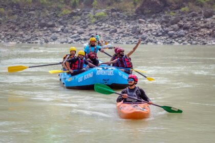 What to wear kayaking shown by a paddler in a life jacket and quick-dry clothing on calm water
